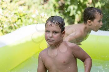 two boys poured water from the pool in nature