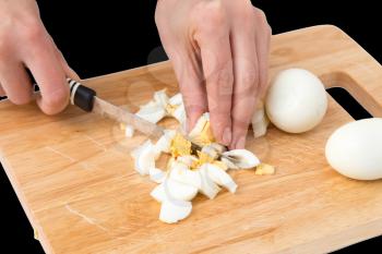 cook eggs on cutting board on a black background