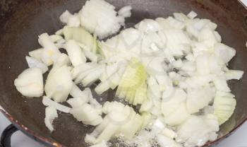 Onion is fried in a pan