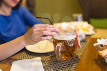 Girl with a mug of beer in a restaurant .