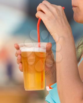 A glass of beer in the girl's hand .