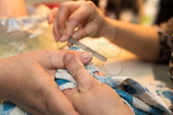 Female manicure on hands in a beauty salon .
