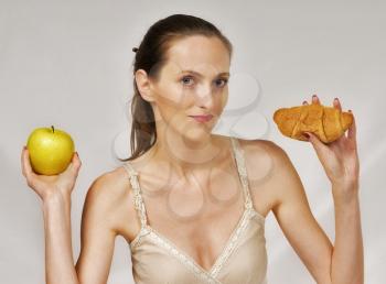 Dilemma - yellow apple or croissant, healthy lifestyle