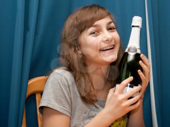 Royalty Free Photo of a Girl Holding a Bottle of Champagne