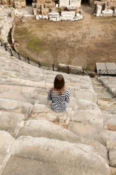 Royalty Free Photo of a Girl Sitting at Amphitheater Ruins in Turkey