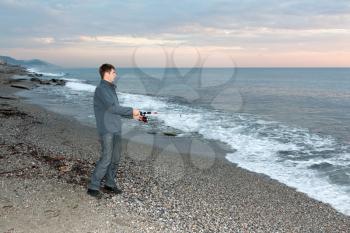 Royalty Free Photo of a Man Fishing at the Shore