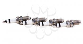 Set of four spark plugs the car on a white background