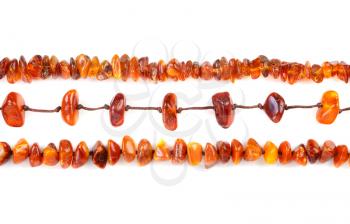 Beads of amber laid in a row isolated on white background