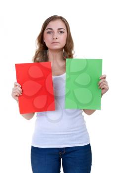 A serious girl shows green and red desert sheets of paper on a white background