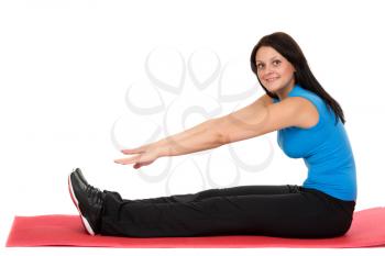 Young beautiful girl sitting on a yoga mat. Isolated on white background