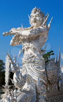 sculpture soldier guards the entrance to the white temple in Chiang Mai, Thailand.
