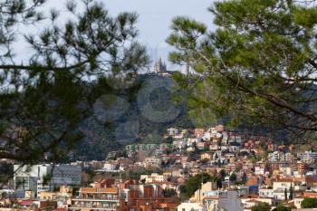 View of Mount Tibidabo through the branches of pine trees. Barcelona, ​​Spain.