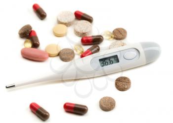 Electronic thermometer and pills isolate on white.