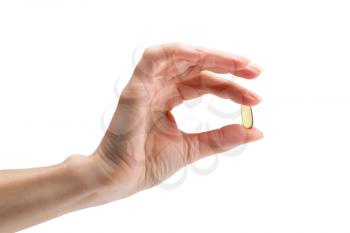 Omega 3 in female fingers on a white background.