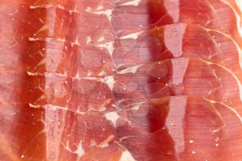 Spanish jamon, dry-cured ham thin slicing for background. Top view