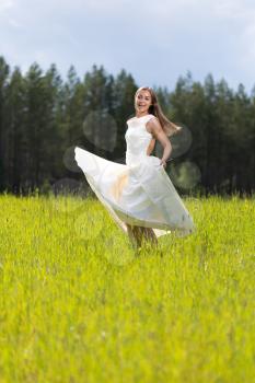 woman in a wedding dress with a smile in a field