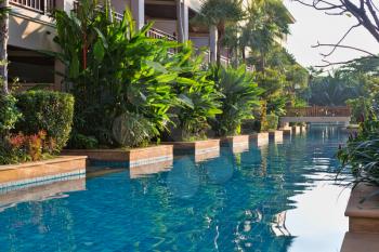 Pool near the elegant villas with tropical plants.