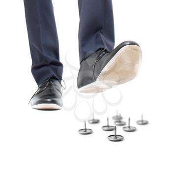 Royalty Free Photo of a Businessman Stepping on Pins