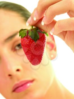Royalty Free Photo of a Woman Looking at a Strawberry