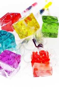 bounch of colorfull translucent dice shaped lollipops backlit on white background