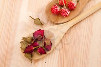dry floral herbal tea on wood spoon over wooden table