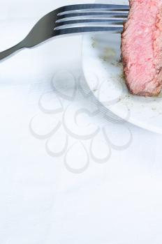 fresh juicy beef ribeye steak slice grilled with fork over a plate