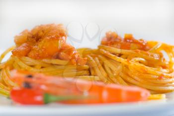italian spaghetti pasta and fresh spicy shrimps sauce over white