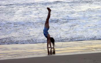 Royalty Free Photo of a Little Girl Doing A Handstand On The Beach