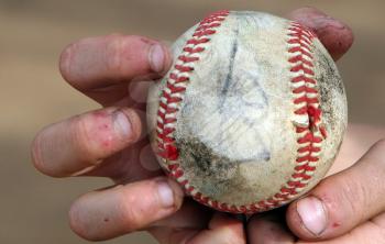 Royalty Free Photo of a Person Holding a Baseball