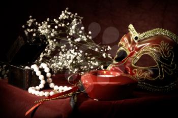 Royalty Free Photo of a Mask, Candle and Beads on Velvet