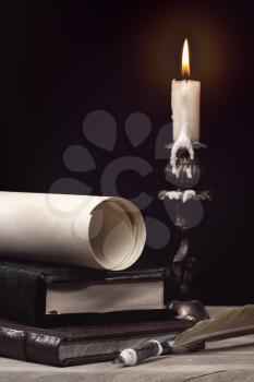 Royalty Free Photo of a Candle, Books, a Pen and Paper
