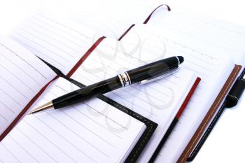 Royalty Free Photo of a Pen on Notebooks