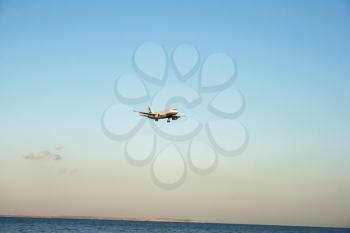 Royalty Free Photo of an Airplane Flying Over Water