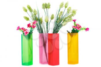 Colorful fabric flowers in glass vases isolated on white background.
