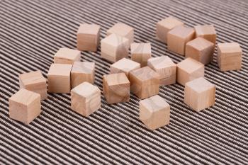 Wooden cubes on striped fabric background.