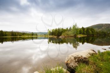 Landscape with mountains, forest and lake in Norway.
