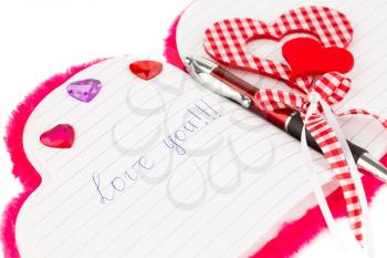 Red hearts, pen  on opened notepad on white background. Inscription Love You.