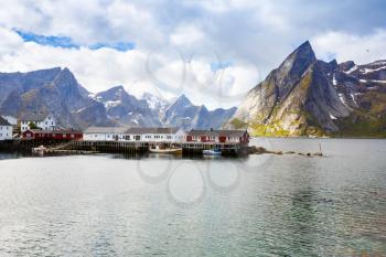 Landscape with high rocky mountains, traditional houses and fjord in Hamnoya, Norway.
