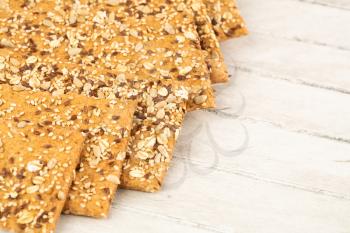 Pile of crackers on gray wooden background.