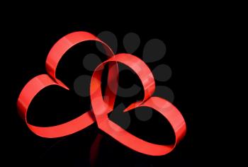 St. Valentine Day. Two hearts, on black background with reflection.