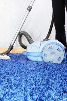 Powelful vacuum cleaner in action-a men cleaner a carpet.