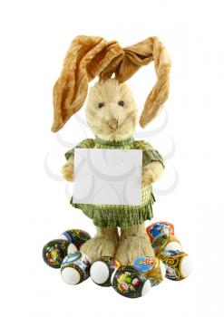 Straw rabbit with blank card in hands . Isolated