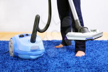 Powelful vacuum cleaner in action-a men cleaner a carpet.