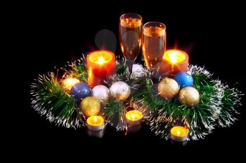 Christmas and New Year decoration- balls, tinsel, candel and glasses of champagne .On black background.