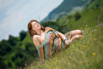 beautiful woman in dress sitting on the grass
