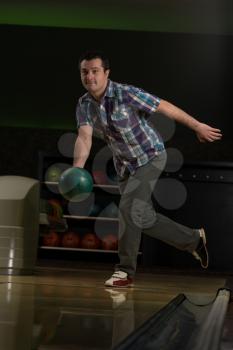 Smiling Young Man Playing With A Bowling Ball