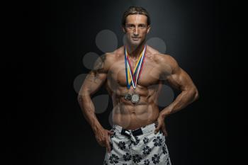 Male Fitness Competitor Showing His Winning Medal