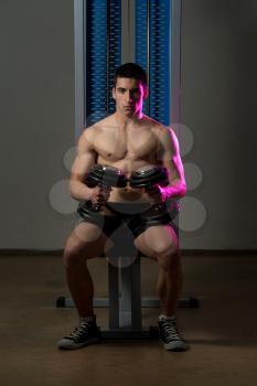 Young Men Exercising Biceps With Dumbbells