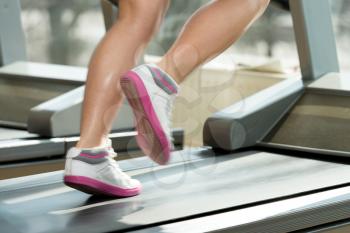 Close-Up Of Female Legs Running On Treadmill - Blurred Motion