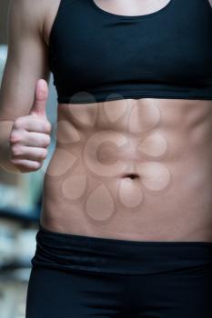 Beautiful Sporty Woman Showing Thumbs Up And Her Ab